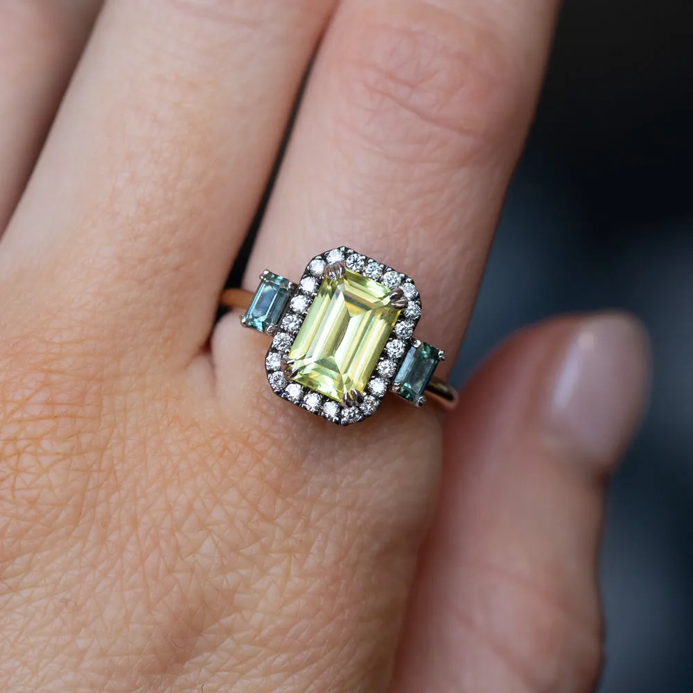 2.62ct Emerald Cut Nigerian Sapphire and Montana Sapphire Low Profile Scallop Cut Three Stone Ring with Antiqued Diamond Halo in 18k Yellow Gold