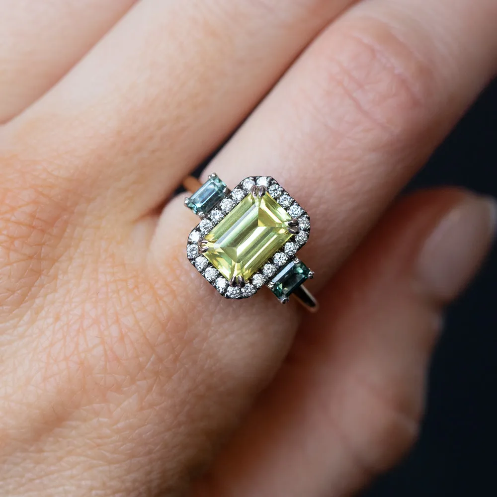 2.62ct Emerald Cut Nigerian Sapphire and Montana Sapphire Low Profile Scallop Cut Three Stone Ring with Antiqued Diamond Halo in 18k Yellow Gold