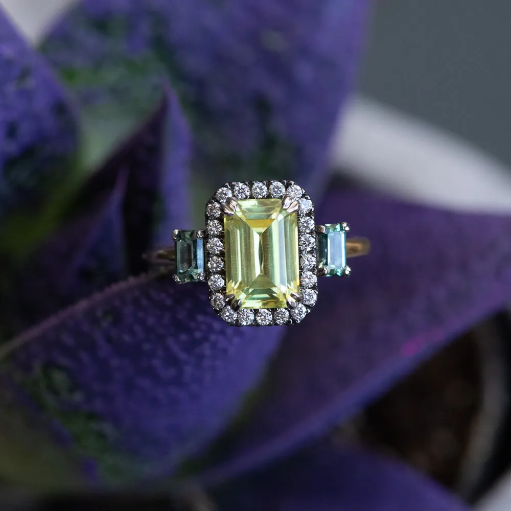 2.62ct Emerald Cut Nigerian Sapphire and Montana Sapphire Low Profile Scallop Cut Three Stone Ring with Antiqued Diamond Halo in 18k Yellow Gold